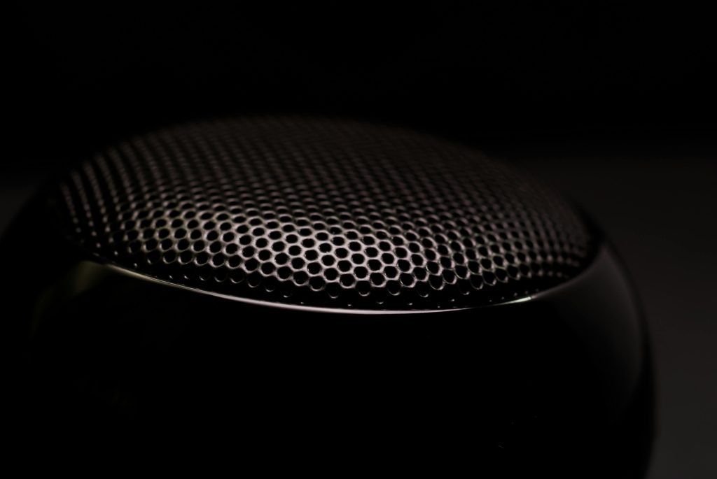 Detailed close-up of a black speaker grill, capturing its sleek and modern design